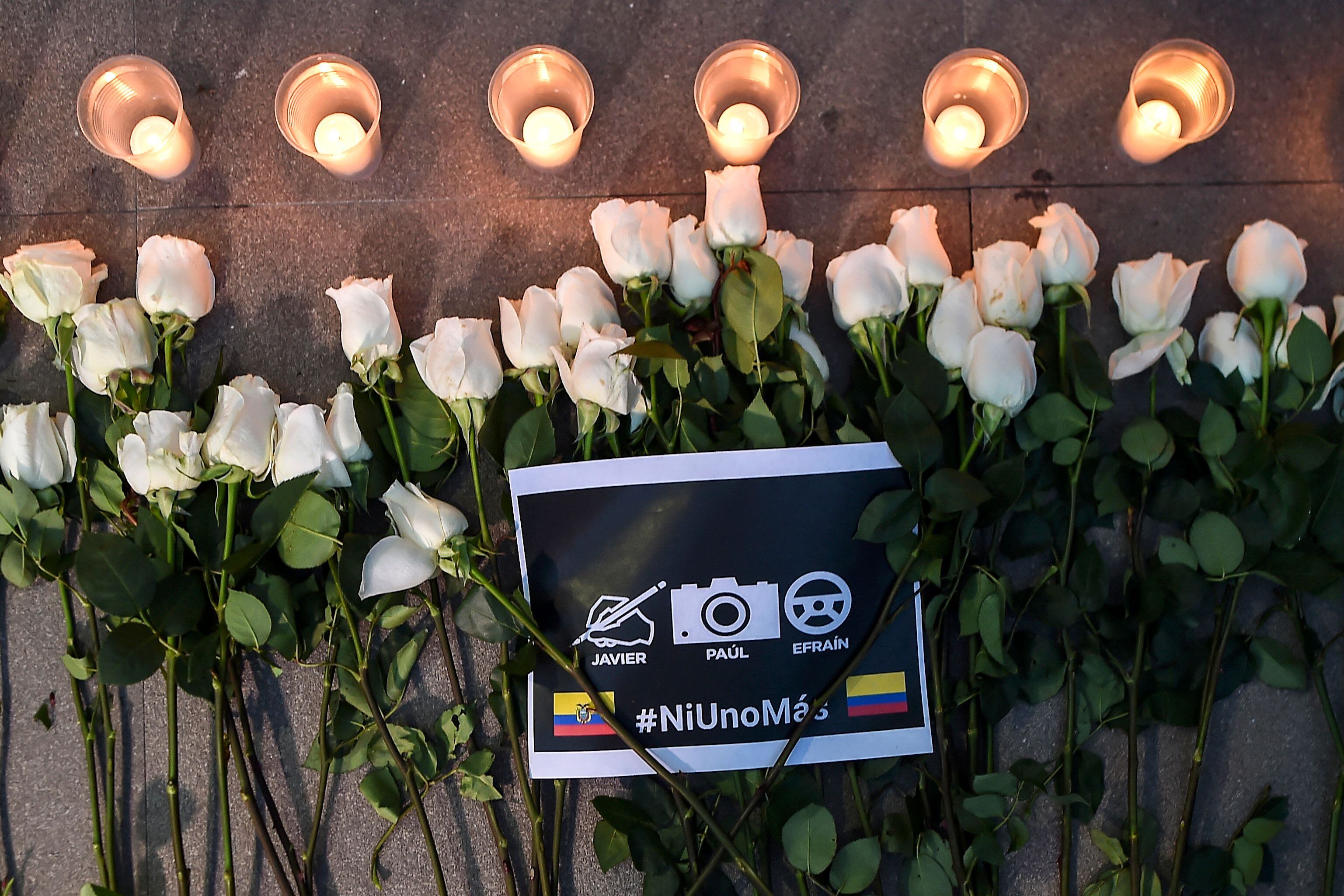 Flores, velas y un cartel que dice «Ni uno más» se ven durante el funeral del periodista ecuatoriano de El Comercio Javier Ortega, el fotógrafo Paul Rivas y el conductor Efraín Segarra en Cali, Colombia, el 26 de junio de 2018. (Luis Robayo/AFP vía Getty Images)