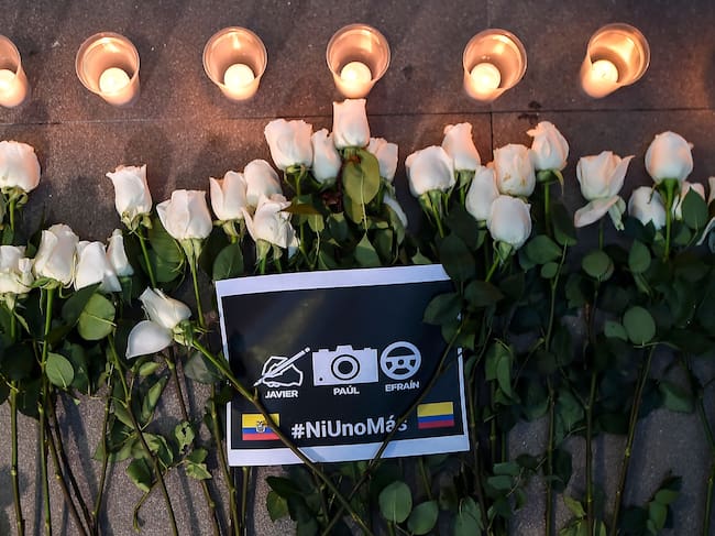 Flores, velas y un cartel que dice «Ni uno más» se ven durante el funeral del periodista ecuatoriano de El Comercio Javier Ortega, el fotógrafo Paul Rivas y el conductor Efraín Segarra en Cali, Colombia, el 26 de junio de 2018. (Luis Robayo/AFP vía Getty Images)
