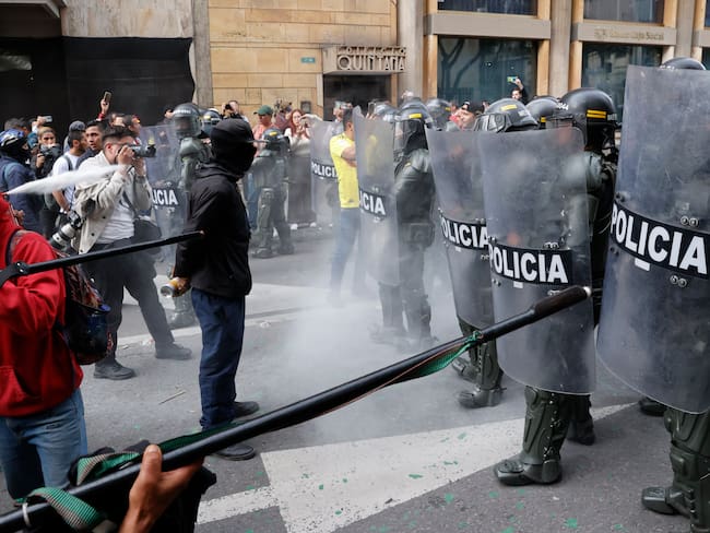 AME7197. BOGOTÁ (COLOMBIA), 08/02/2024.- Personas se enfrentan con la Policía durante una protesta hoy en Bogotá (Colombia). El presidente de la Corte Suprema de Justicia de Colombia, Gerson Chaverra, condenó este jueves en duros términos el &quot;bloqueo violento e ilegal&quot; de manifestantes afines al Gobierno al Palacio de Justicia, situado en el centro de Bogotá, acto que consideró &quot;inaceptable&quot;. EFE/Mauricio Dueñas Castañeda