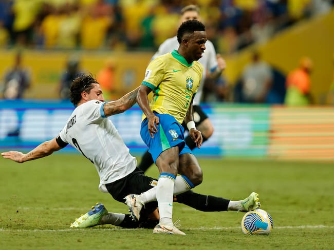 Vinicius Jr (d) de Brasil disputa el balón con José María Giménez de Uruguay este martes, en un partido de las eliminatorias sudamericanas para el Mundial de 2026 entre Brasil y Uruguay, en el estadio Arena Fonte Nova en Salvador (Brasil). EFE/ Isaac Fontana