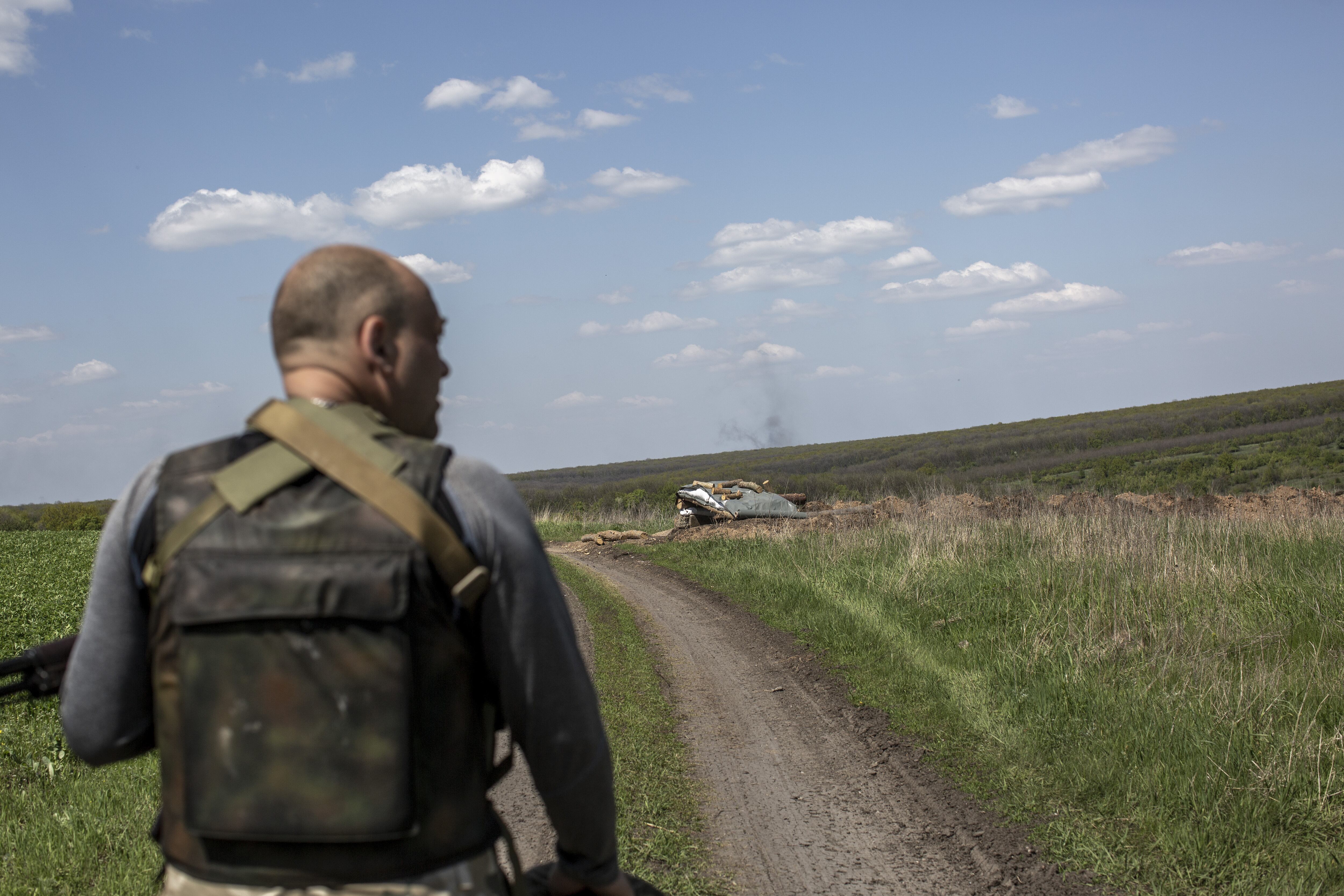 CHERKASKE, DONETSK PROVINCE, UKRAINE, MAY 3: A Ukrainian serviceman walks behind to the trenches as smoke rises from clashes against Russian troops near to Cherkaske City, on eastern Ukraine, May 3, 2022. (Photo by Narciso Contreras/Anadolu Agency via Getty Images)