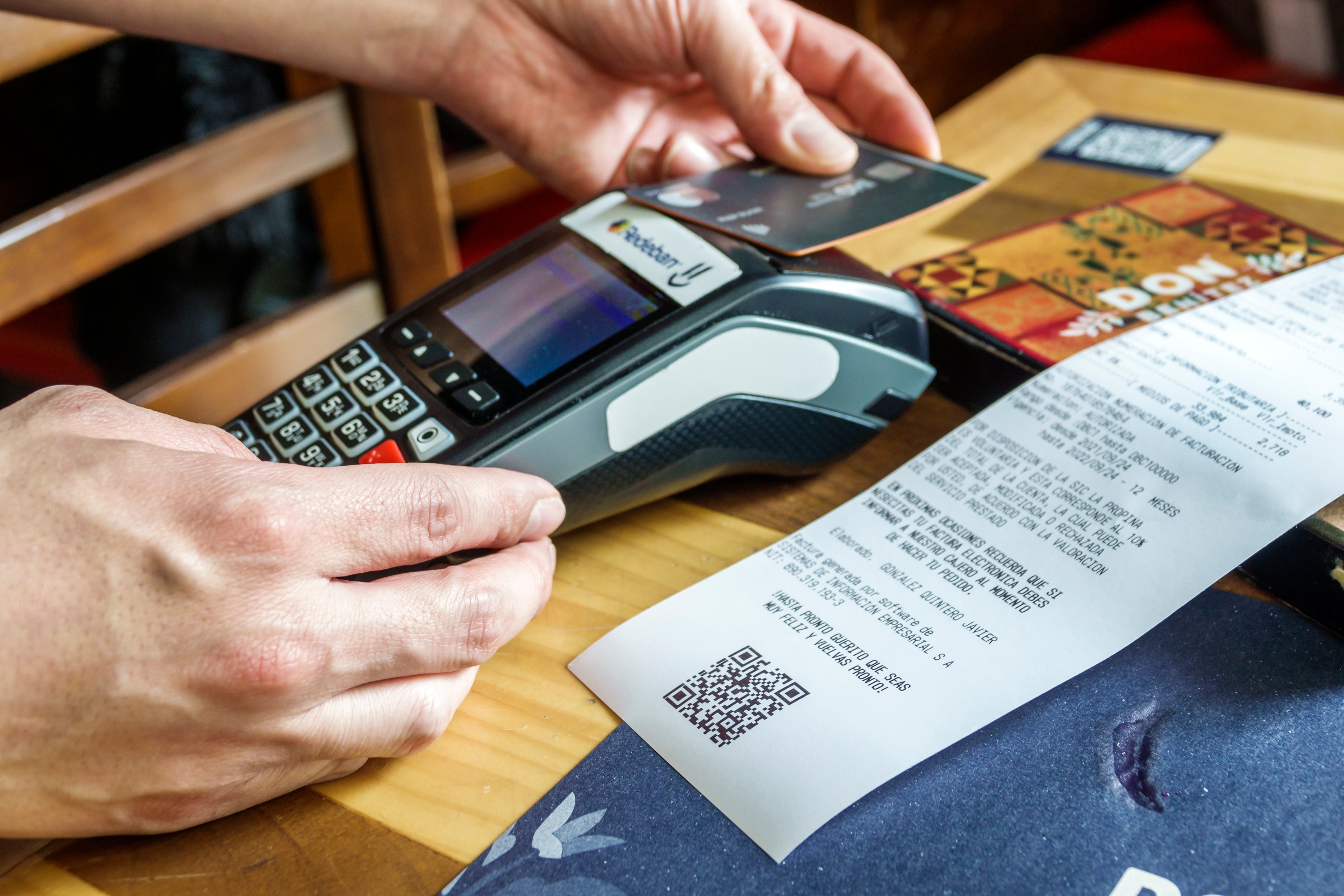 Bogotá, Colombia, La Candelaria. Camarero pasando una tarjeta de crédito por un escáner, junto a un recibo de pago. (Jeffrey Greenberg/Universal Images Group vía Getty Images)
