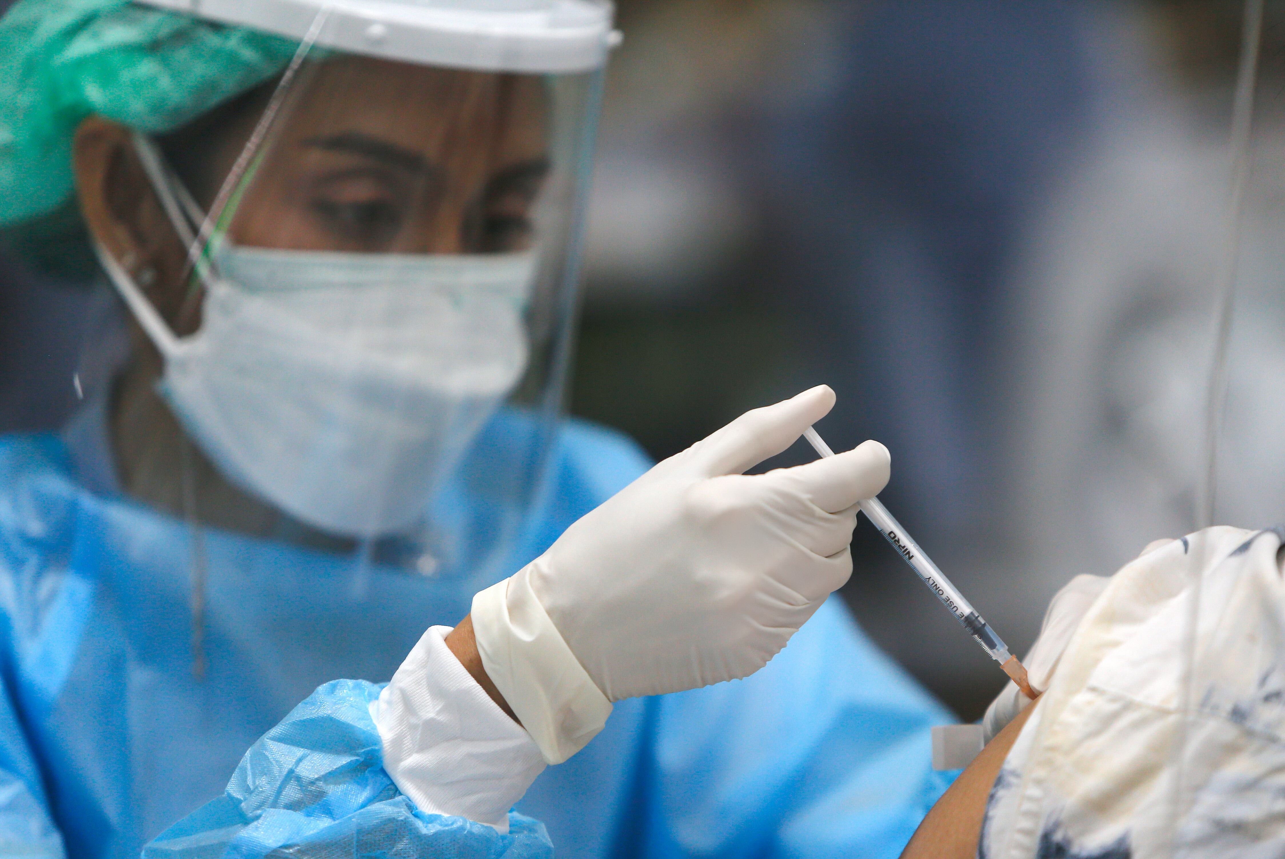 BANGKOK, THAILAND - 2022/01/27: A health worker administers a dose of the Comirnaty (Pfizer) COVID-19 vaccine to a woman at the Central Vaccination Center in Bangkok.Ministry of Public Health reported that in the past 24 hours, 8,078 new patients tested positive for Covid-19, 225 of who have arrived in Thailand from abroad. The death toll increased by 22, while 6,595 patients have recovered from the disease. (Photo by Chaiwat Subprasom/SOPA Images/LightRocket via Getty Images)