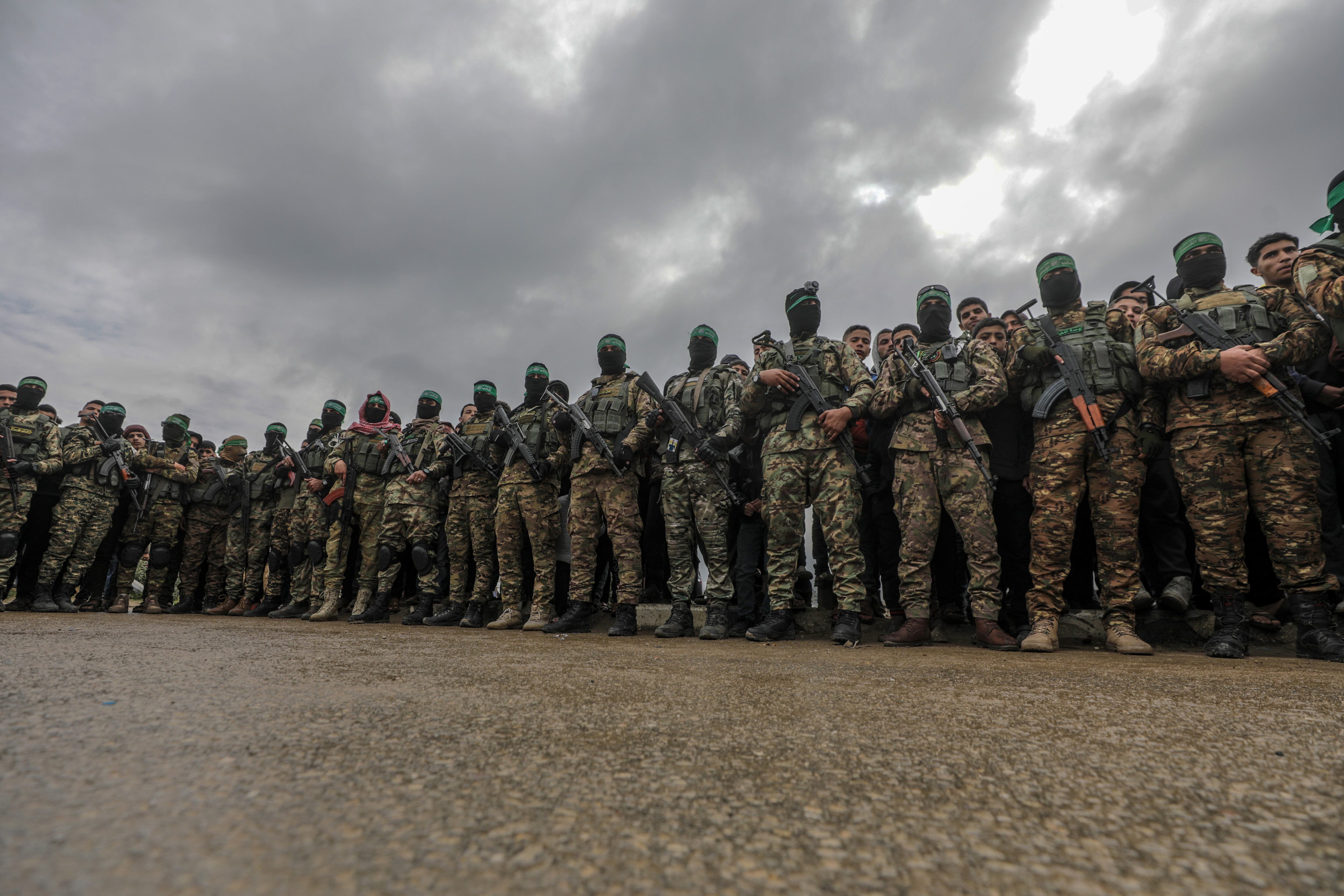 Campo de Nuseirat (-), 22/02/2025.- Combatientes armados de las Brigadas Izz ad-Din al-Qassam, de Hamás, montan guardia durante la entrega de tres rehenes israelíes a representantes de la Cruz Roja.