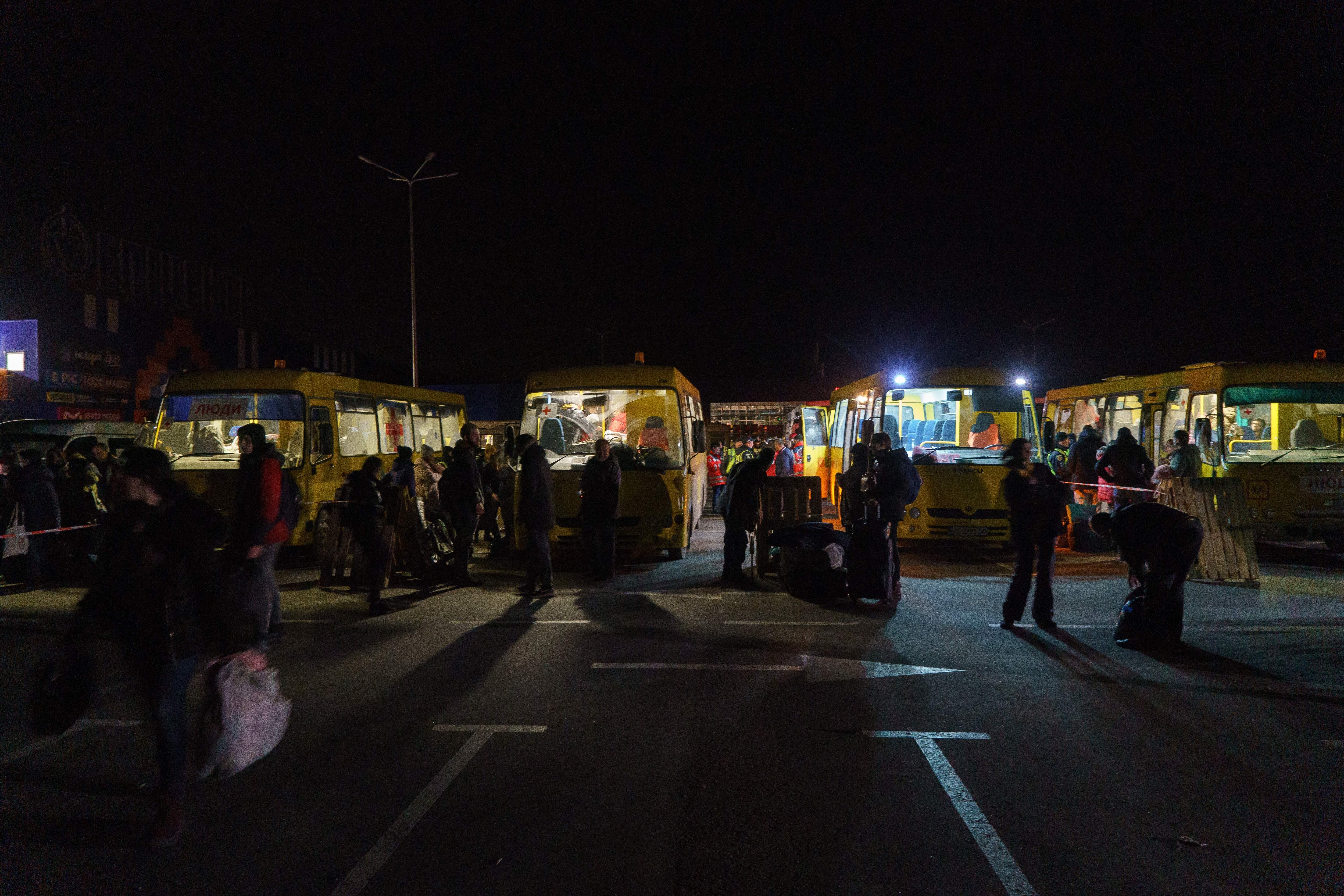 TOPSHOT - Passengers disembark as a convoy of 30 buses carrying evacuees from Mariupol and Melitopol arrive at the registration center in Zaporizhzhia, on April 1, 2022. - Late on April 1, people who managed to flee Mariupol to Russian-occupied Berdiansk were from there carried on dozens of buses to Zaporizhzhia, some 200 kilometers (120 miles) to the northwest, according to an AFP reporter on the scene. (Photo by emre caylak / AFP) (Photo by EMRE CAYLAK/AFP via Getty Images)