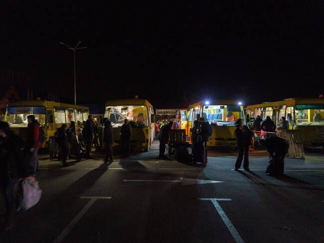 TOPSHOT - Passengers disembark as a convoy of 30 buses carrying evacuees from Mariupol and Melitopol arrive at the registration center in Zaporizhzhia, on April 1, 2022. - Late on April 1, people who managed to flee Mariupol to Russian-occupied Berdiansk were from there carried on dozens of buses to Zaporizhzhia, some 200 kilometers (120 miles) to the northwest, according to an AFP reporter on the scene. (Photo by emre caylak / AFP) (Photo by EMRE CAYLAK/AFP via Getty Images)
