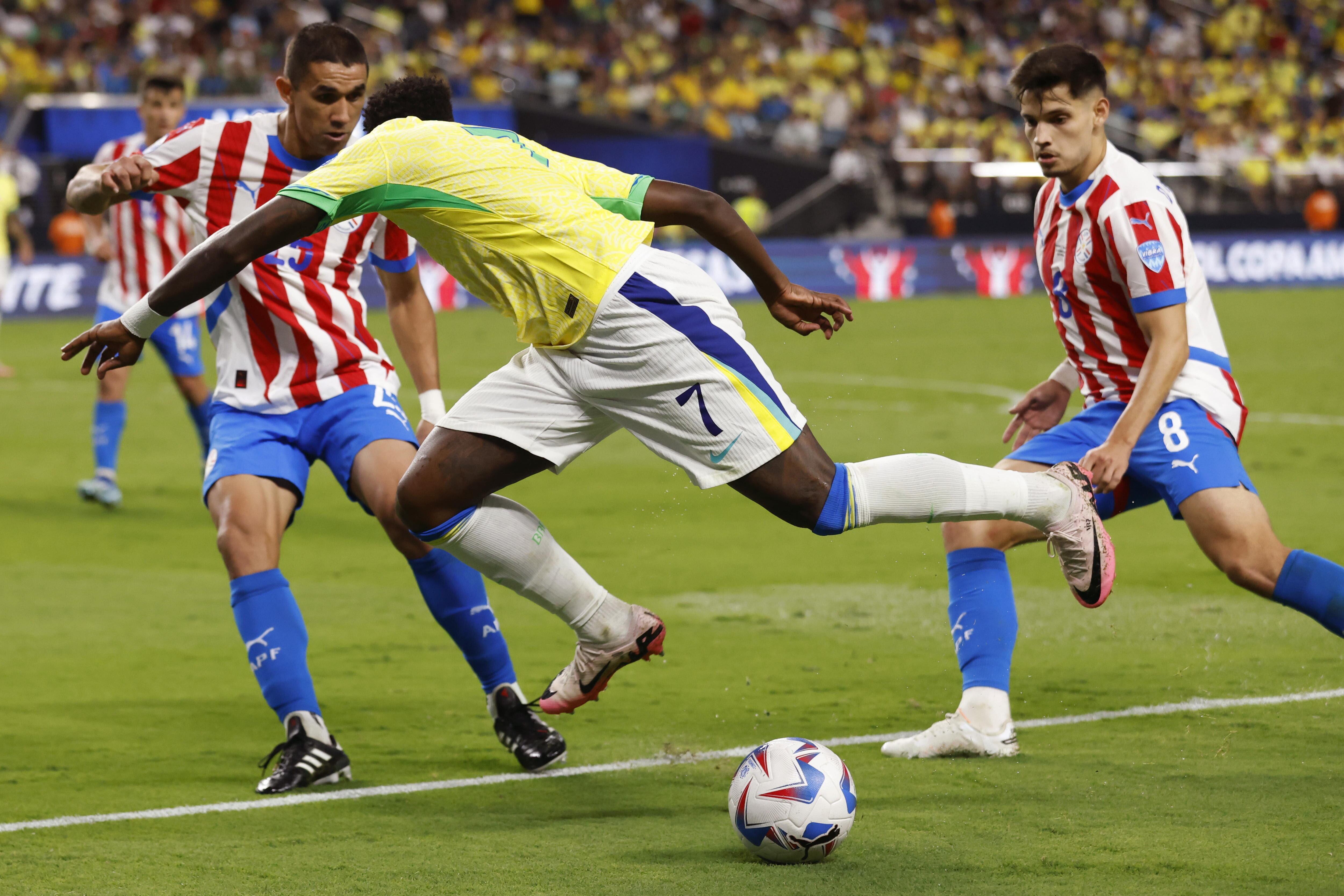 Las Vegas (United States), 29/06/2024.- Brazil forward Vinicius Junior (C) in action against Paraguay defender Gustavo Velazquez (L) and Paraguay midfielder Damian Bobadilla (R) during the second half of the CONMEBOL Copa America 2024 group D soccer match between Paraguay and Brazil, in Las Vegas, Nevada, USA, 28 June 2024. (Brasil) EFE/EPA/CAROLINE BREHMAN