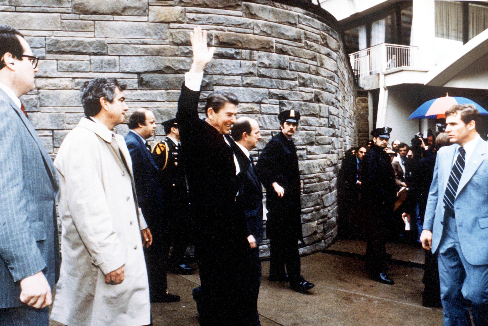 354390 077: President Ronald Reagan Waves To Onlookers Moments Before An Assassination Attempt By John Hinckley Jr March 30, 1981 By The Washington Hilton In Washington Dc.James Brady Is Visible Third From The Left. (Photo By The White House/Getty Images)