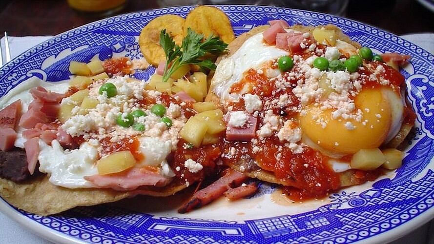 Other/ Una delicia de Yucatán: huevos motuleños, que son fritos y servidos sobre una tostada con frijoles negros, salsa de tomate, jamón y chícharos, con plátano, queso y salsa picante. Imagen tomada de BBC Mundo.