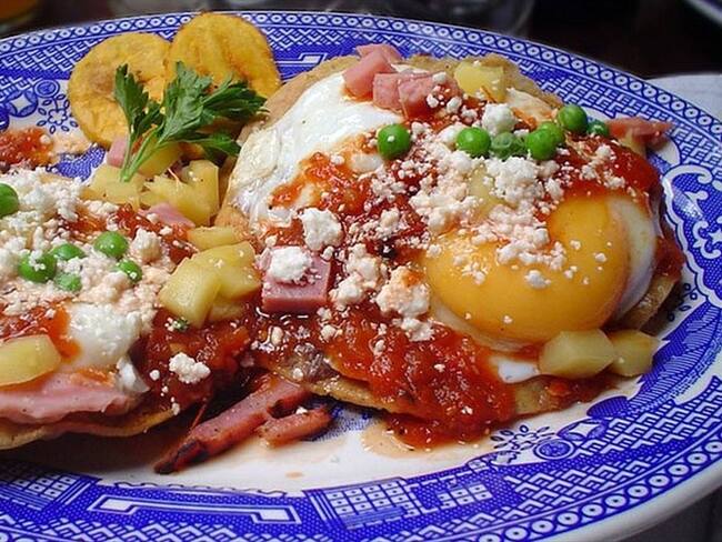 Other/ Una delicia de Yucatán: huevos motuleños, que son fritos y servidos sobre una tostada con frijoles negros, salsa de tomate, jamón y chícharos, con plátano, queso y salsa picante. Imagen tomada de BBC Mundo.