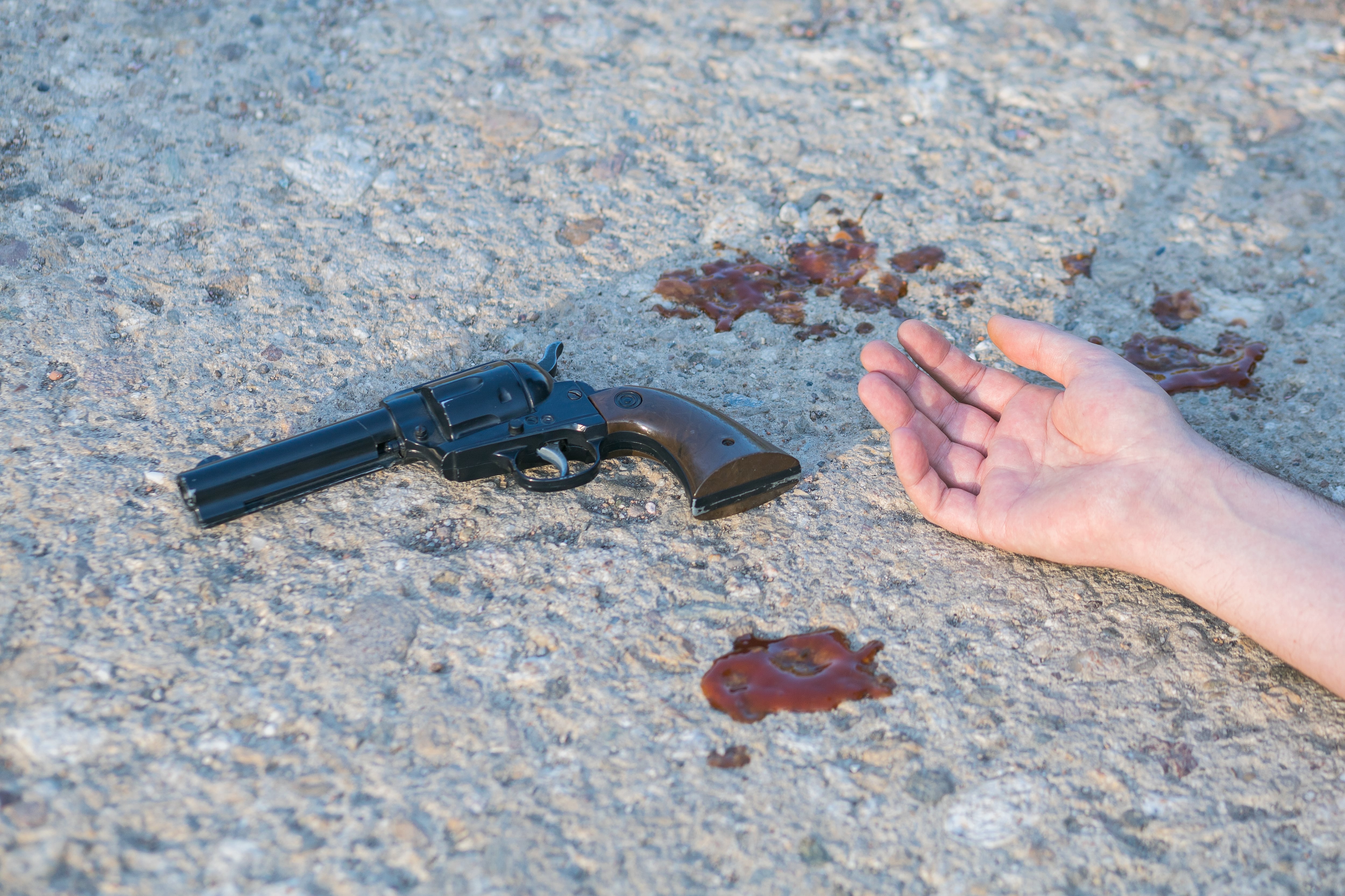 hand and gun at murder scene