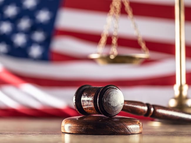 Gavel and scales with a US flag in the background as symbols of a jurisdiction.