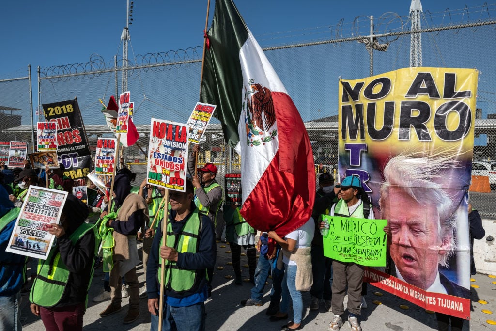 Migrantes protestando en la frontera de México en contra de Donald Trump. I Foto: GUILLERMO ARIAS/AFP via Getty Images.