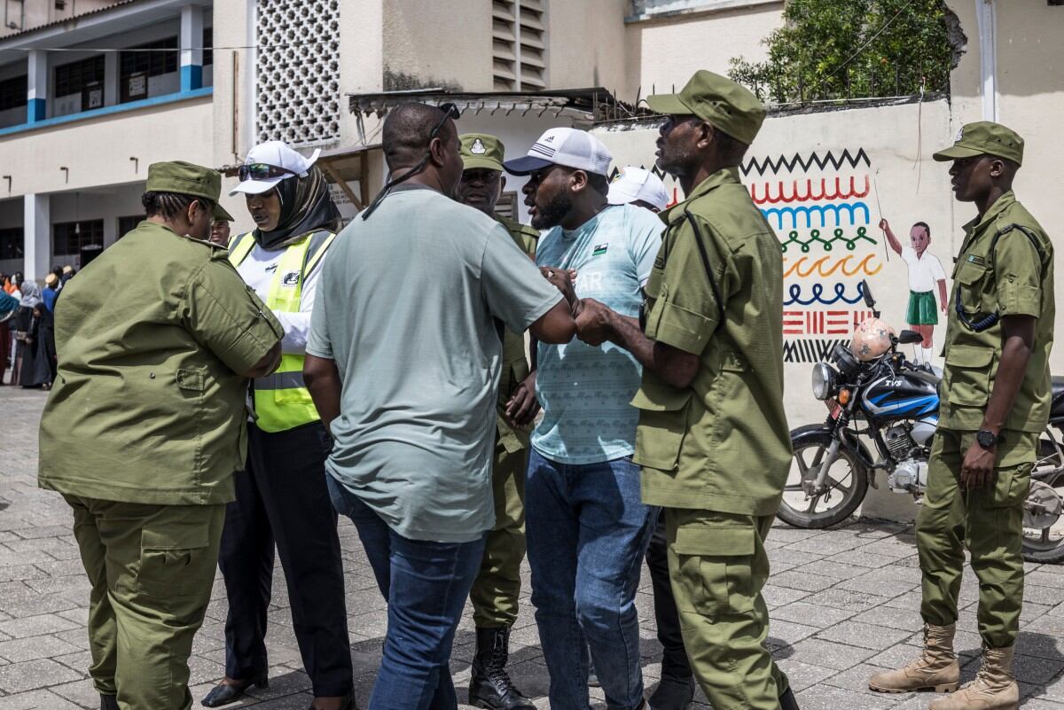Policías deteniendo a un hombre en jornada electoral. Foto: MARCO LONGARI / AFP