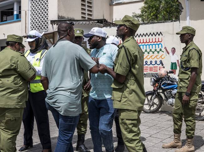Policías deteniendo a un hombre en jornada electoral. Foto: MARCO LONGARI / AFP