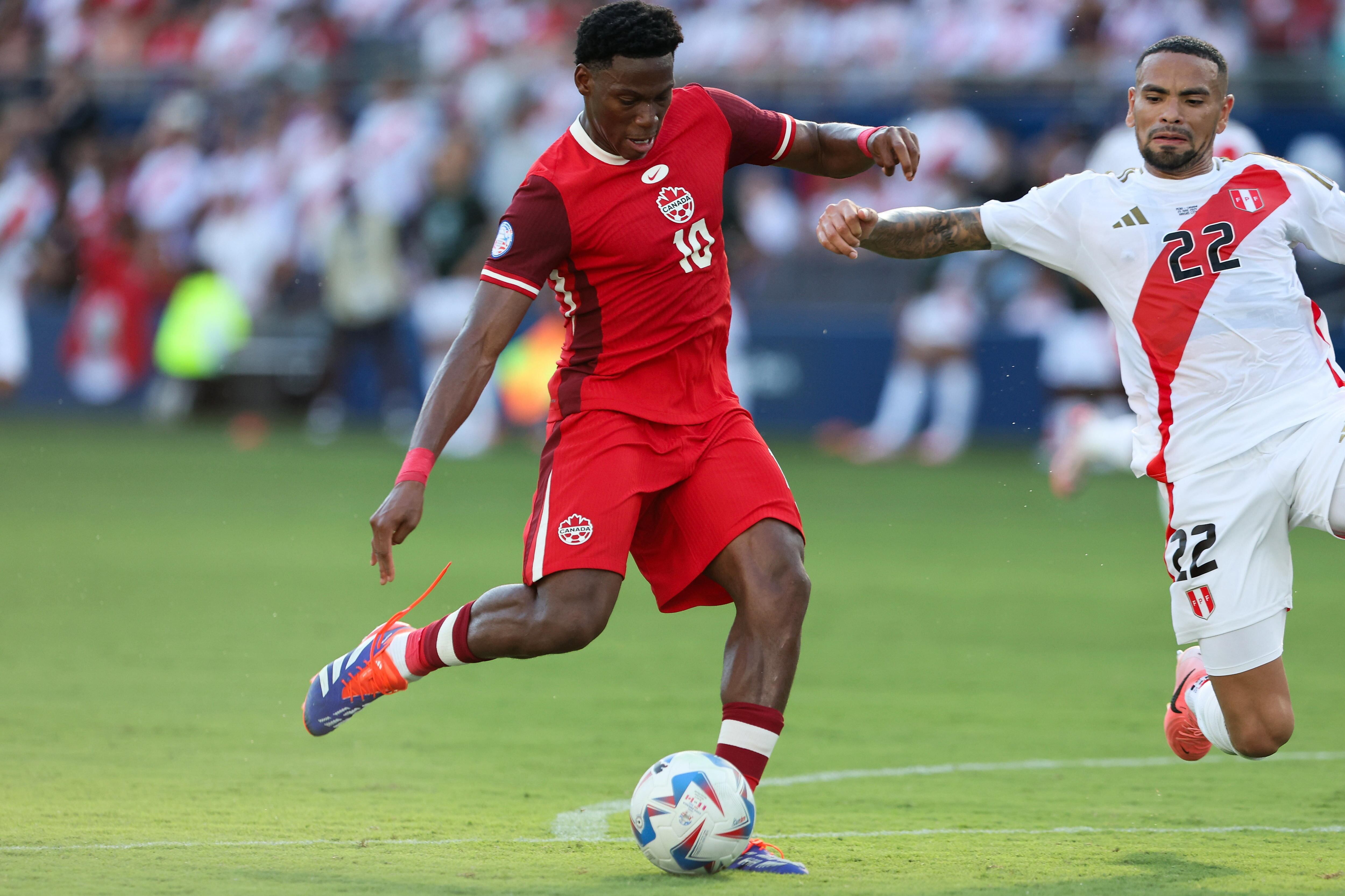 Kansas City (United States), 25/06/2024.- Canada forward Jonathan David (L) shoots and scores past Peru defender Alexander Callens (R) during the second half of the CONMEBOL Copa America 2024 group A match between Peru and Canada, in Kansas City, Kansas, USA, 25 June 2024. EFE/EPA/WILLIAM PURNELL