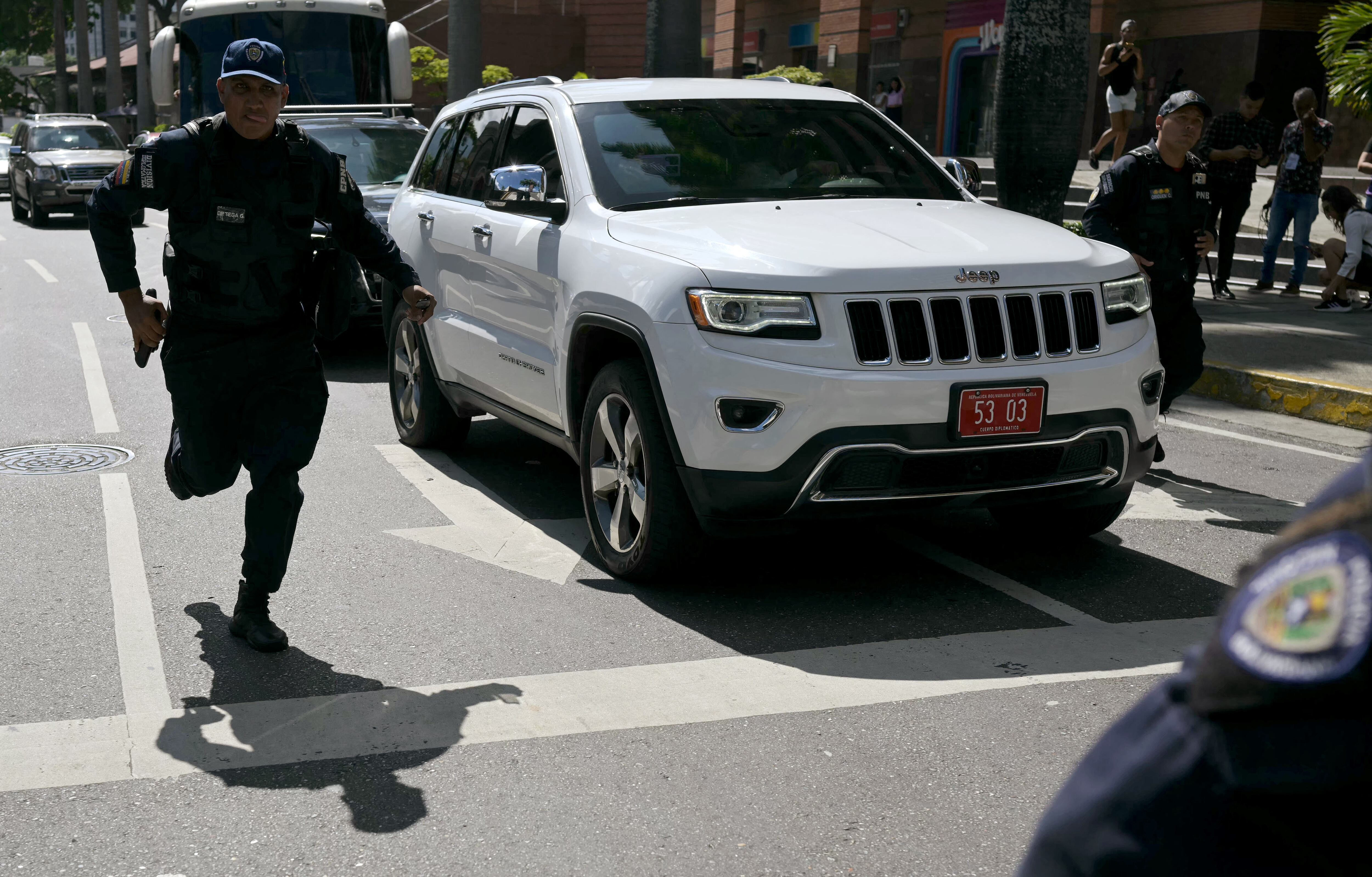 Oficiales de la policía venezolana escoltan carros de la embajada argentina. FOTO: YURI CORTEZ/AFP via Getty Images