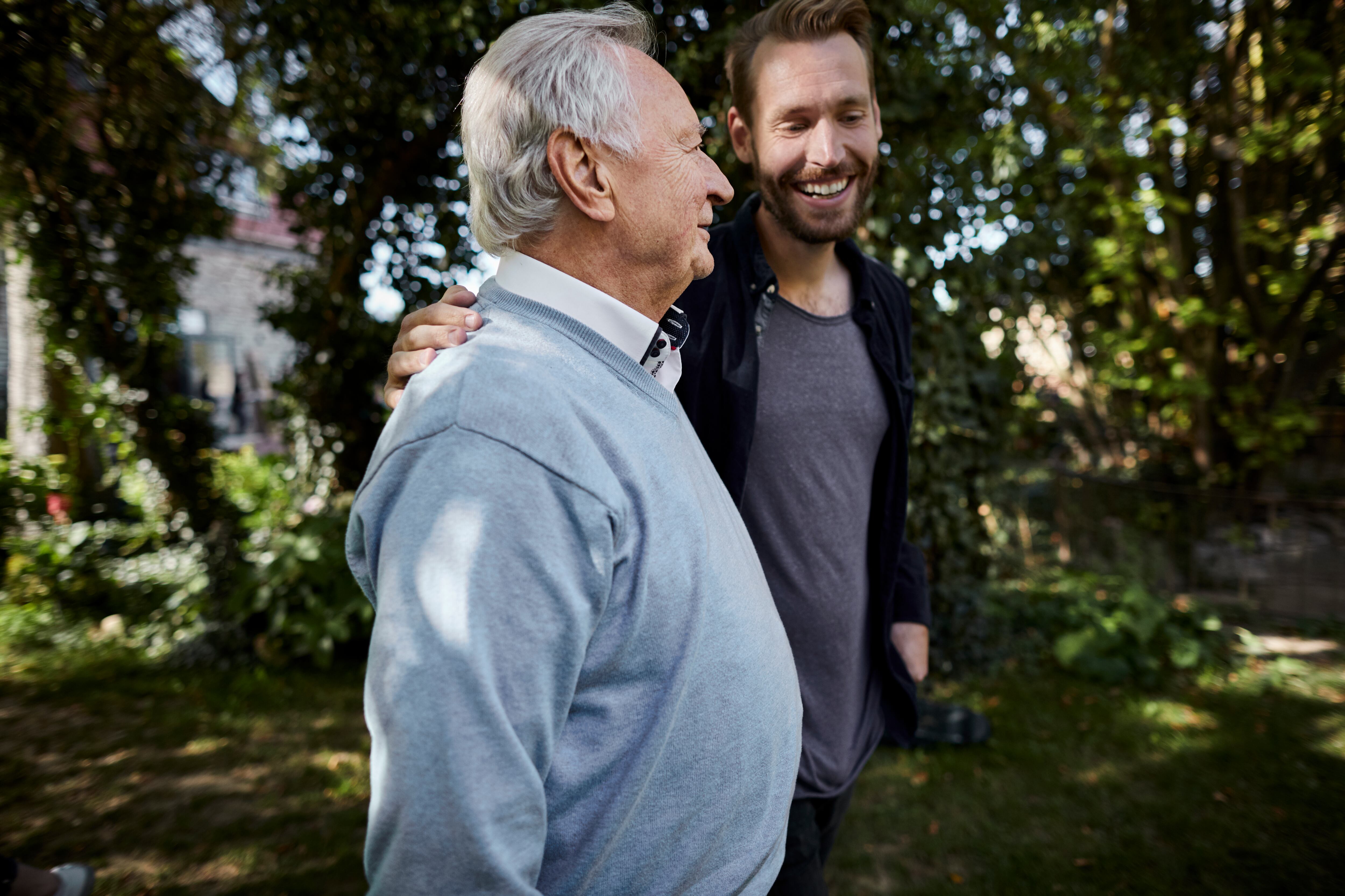 Dos hombres hablando mientras caminan por un jardín (Foto vía GettyImages)
