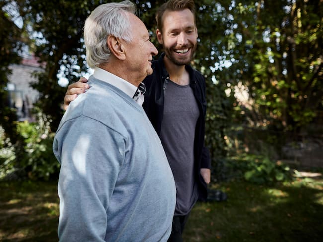 Dos hombres hablando mientras caminan por un jardín (Foto vía GettyImages)