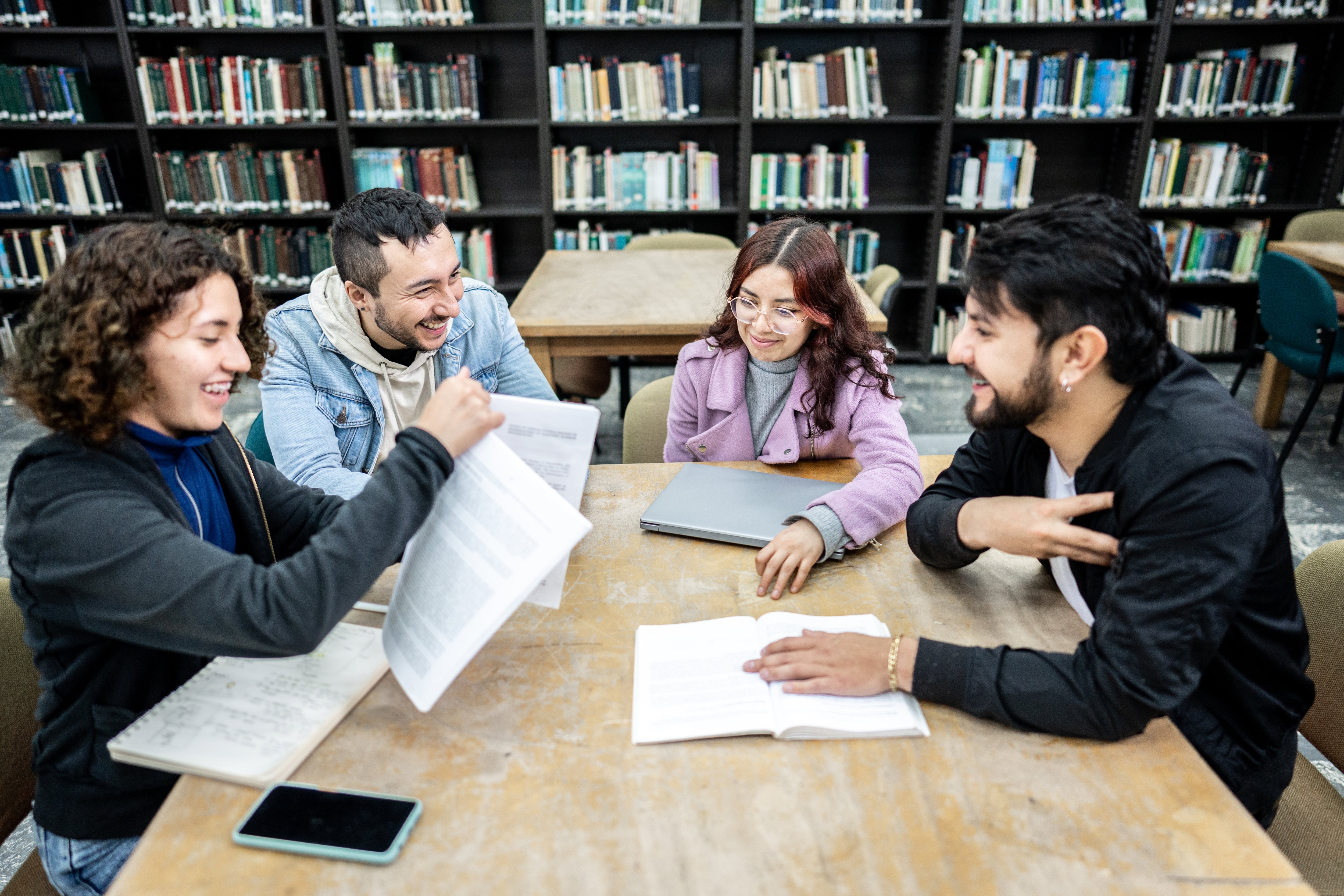 Estudiantes universitarios compartiendo en la biblioteca (Foto vía Getty Images)