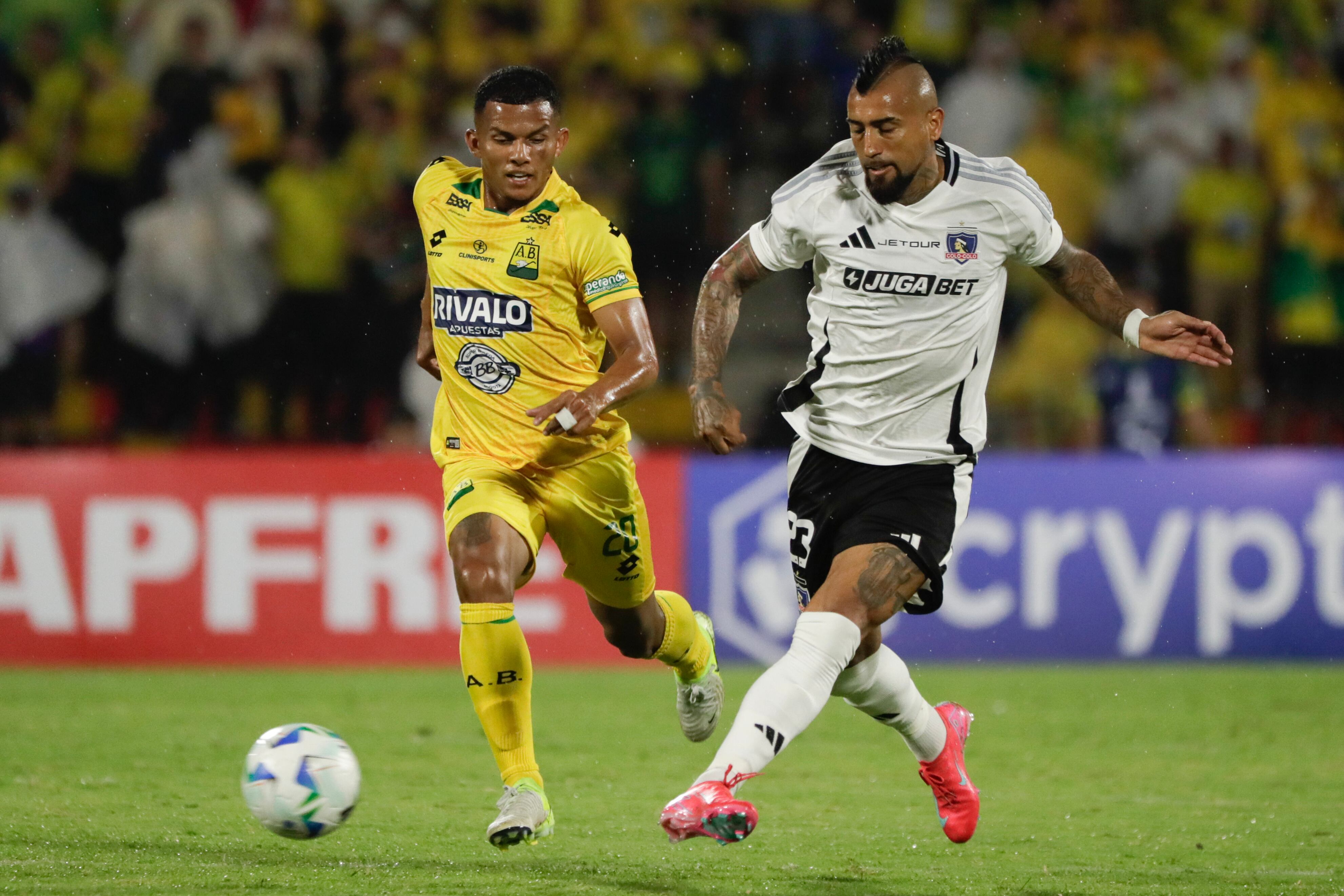 Aldair Enrique Zárate de Bucaramanga disputa un balón con Arturo Vidal de Colo-Colo en el primer partido de la fase de grupos. FOTO: EFE/ Carlos Ortega