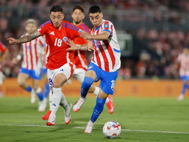 Miguel Almirón (d) de Paraguay disputa un balón con Rodrigo Echeverría de Chile en un partido de las eliminatorias sudamericanas para el Mundial de 2026. Foto: EFE/ Juan Pablo Pino