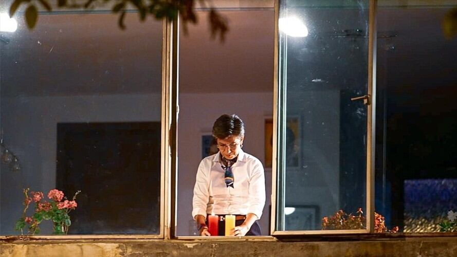 Desde la ventana de su casa, la alcaldesa encendió dos velas e invitó a todos los ciudadanos a hacer lo mismo para honrar la memoria de quienes han fallecido por causa del virus. Foto: Cortesía Alcaldía