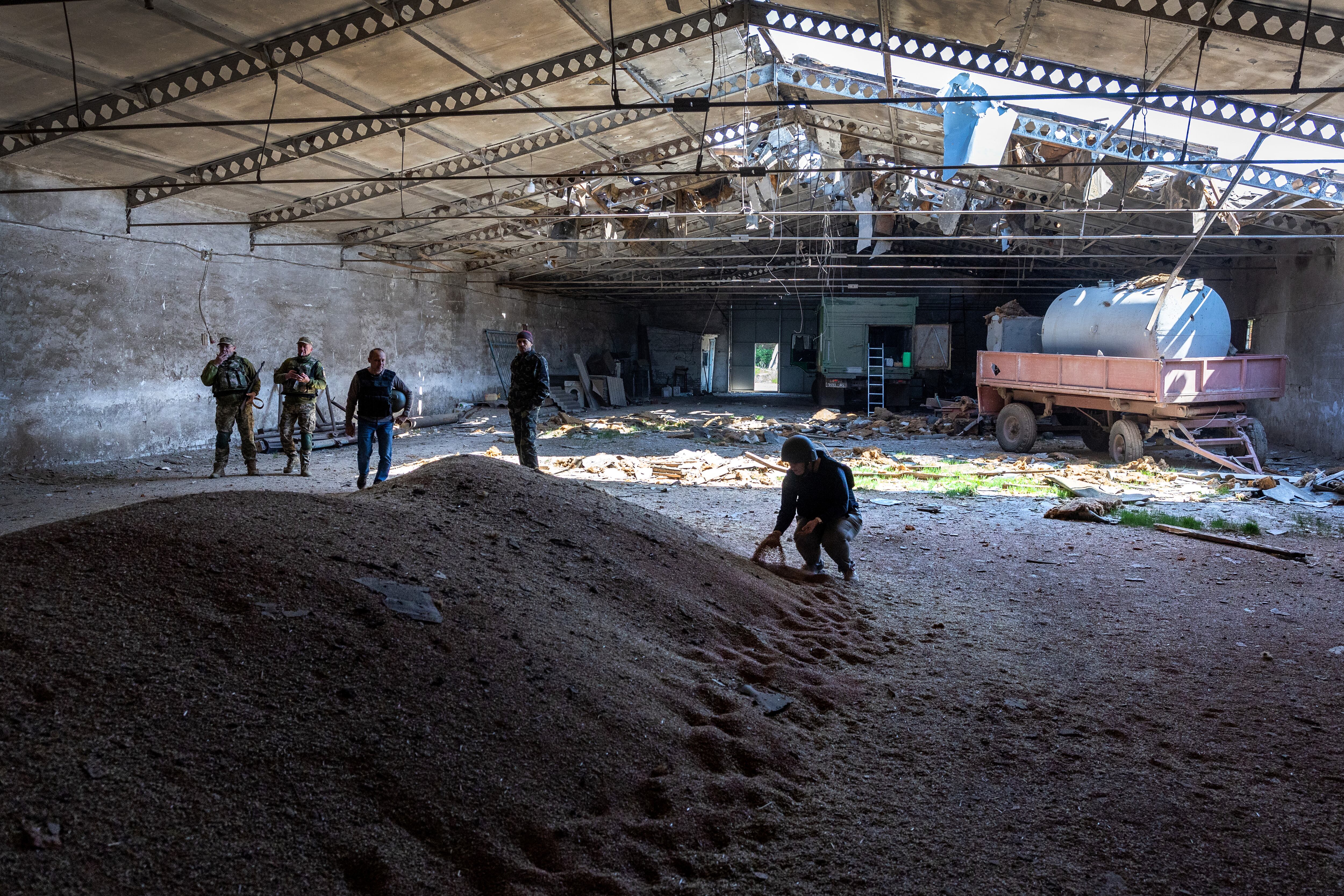 NOVOVORONTSOVKA, UKRAINE - MAY 06: Local government officials and  Ukrainian soldiers inspect a wheat grain warehouse earlier shelled by Russian forces on May 06, 2022 near the frontlines of Kherson Oblast in Novovorontsovka, Ukraine. (Photo by John Moore/Getty Images)