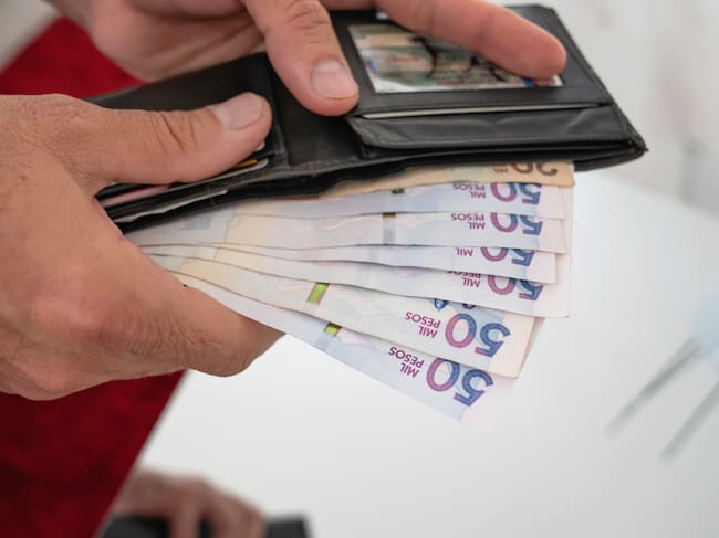 Imagen de referencia de persona con dinero colombiano. Foto: Getty Images