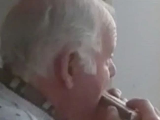 La conmovedora historia del anciano que toca la armónica por la ventana durante cuarentena. Foto: Captura de Pantalla