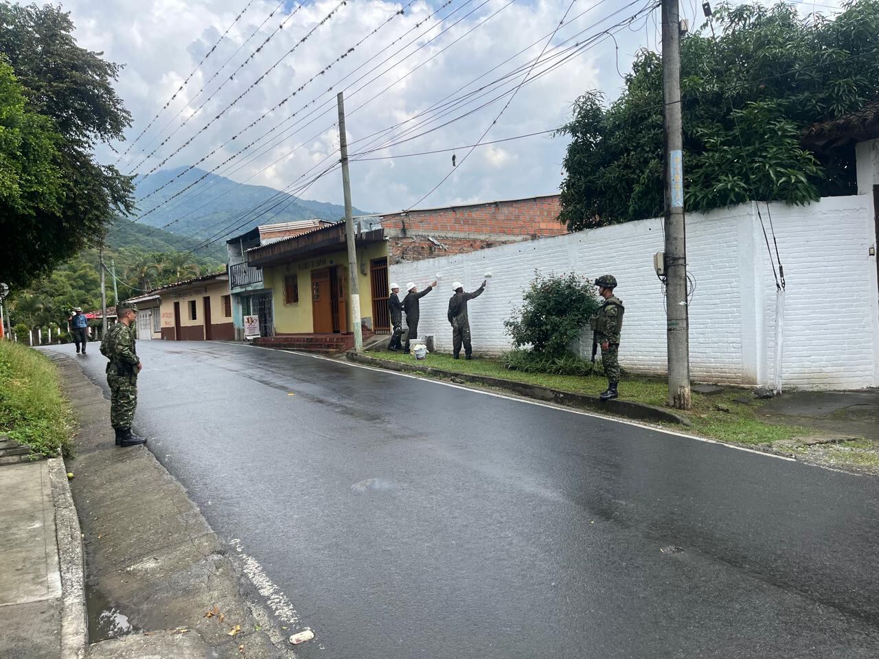 Miembros del Ejército Nacional cubren con pintura blanca un muro que contenía propagana de las disidencias de las Farc en Valle del Cauca. (Cortesía - Ejército)