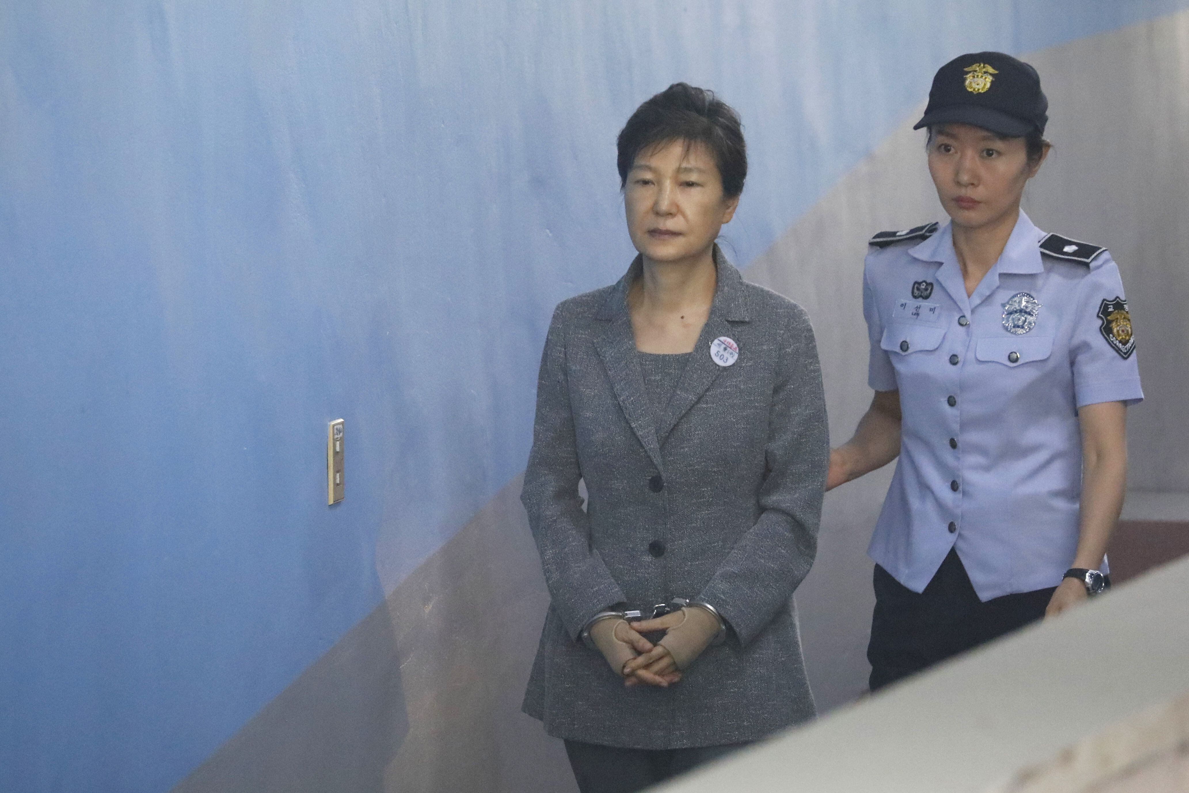 TOPSHOT - South Korean ousted leader Park Geun-hye (L) arrives at a court in Seoul on August 25, 2017.The heir to the Samsung business empire, including the world's biggest smartphone maker, awaited the verdict on August 25 in his corruption trial over the scandal that brought down South Korean president Park Geun-Hye. / AFP PHOTO / POOL / KIM HONG-JI (Photo credit should read KIM HONG-JI/AFP via Getty Images)