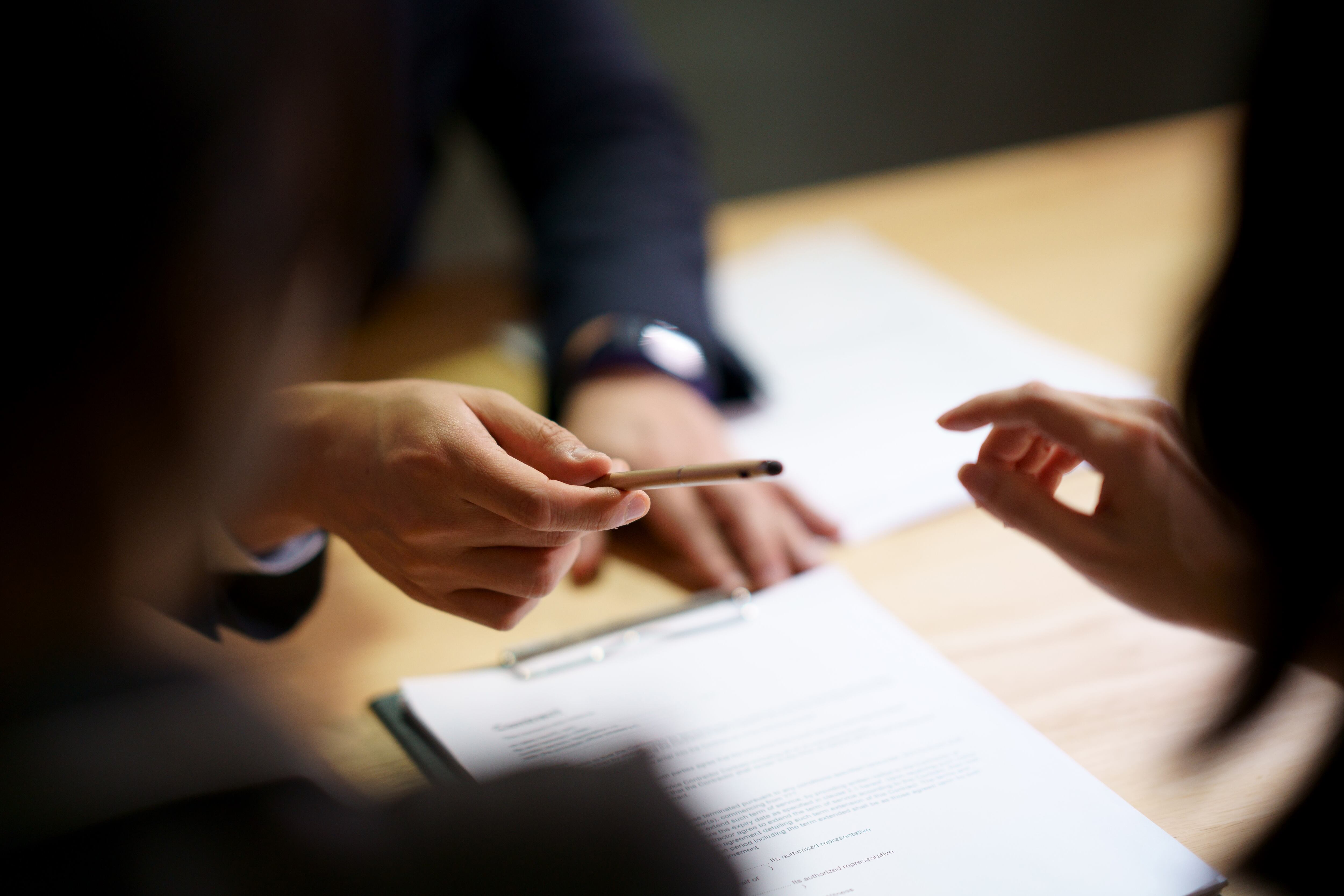 Selective focus shooting on hand of Businessman giving pen to Partnership to sign contract agreement in document