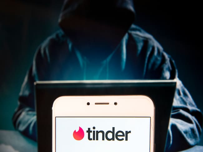 HONG KONG, CHINA - 2018/11/27:  In this photo illustration, the Mobile dating app Tinder logo is seen displayed on an Android mobile device with a figure of hacker in the background. (Photo Illustration by Miguel Candela / SOPA Images/SOPA Images/LightRocket via Getty Images)