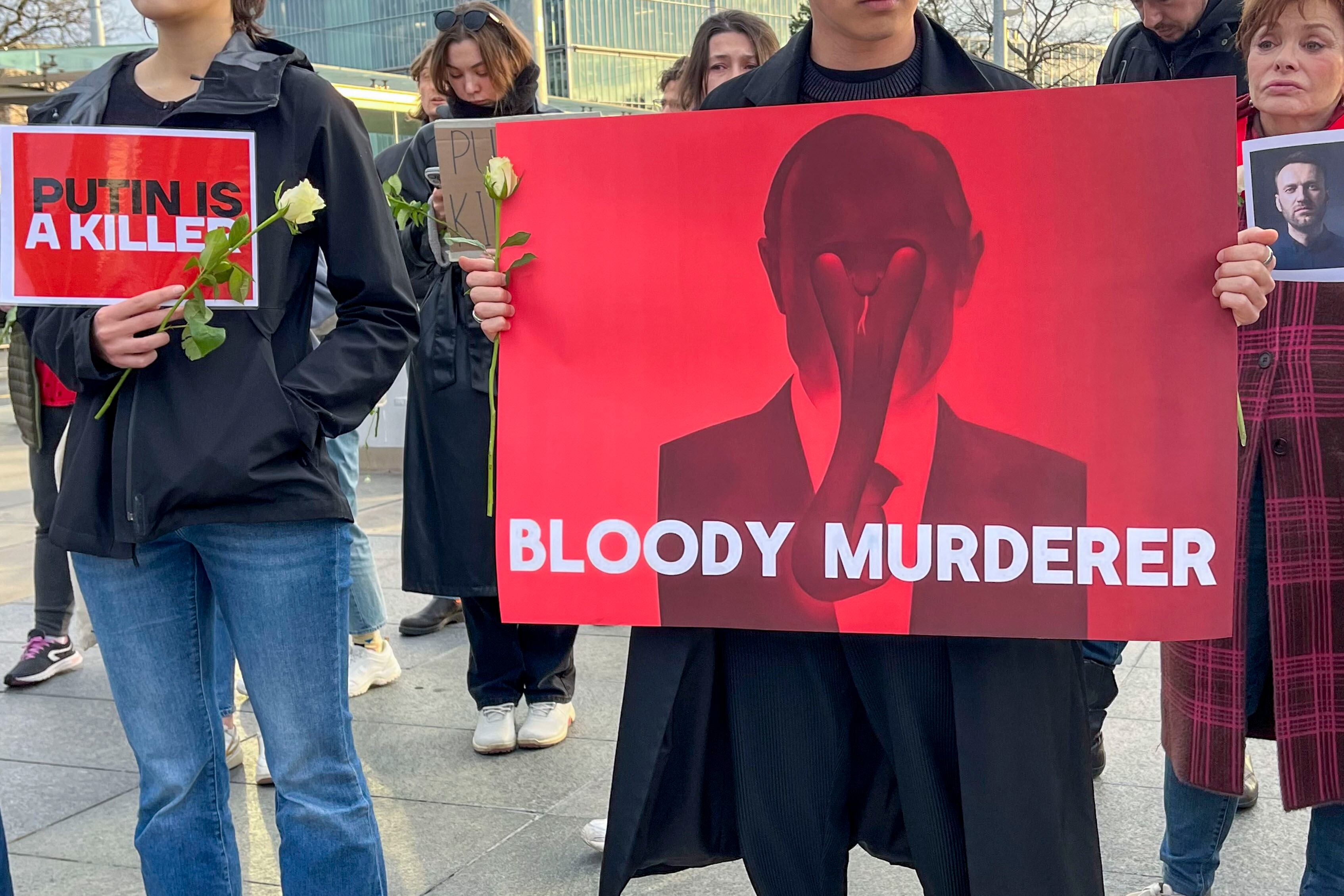 GINEBRA, 16/02/2024.- Un manifestante porta una pancarta con la consigna "Maldito asesino" y una imagen de Putin durante las protestas frente a la sede europea de las Naciones Unidas en Ginebra. Foto: EFE/Anisia Gil