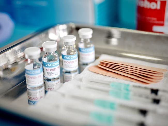 Close up of Vials and Syringes with Covid-19 vaccine are displayed on a tray during vaccination.