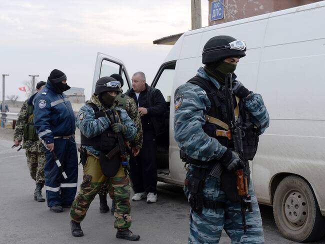 Pro-Russian forces check a van driver's documents and vehicle at a checkpoint in Chongar, in the border area between Crimea and the Kherson region of Ukraine. (Photo credit should read VASILY MAXIMOV/AFP via Getty Images)