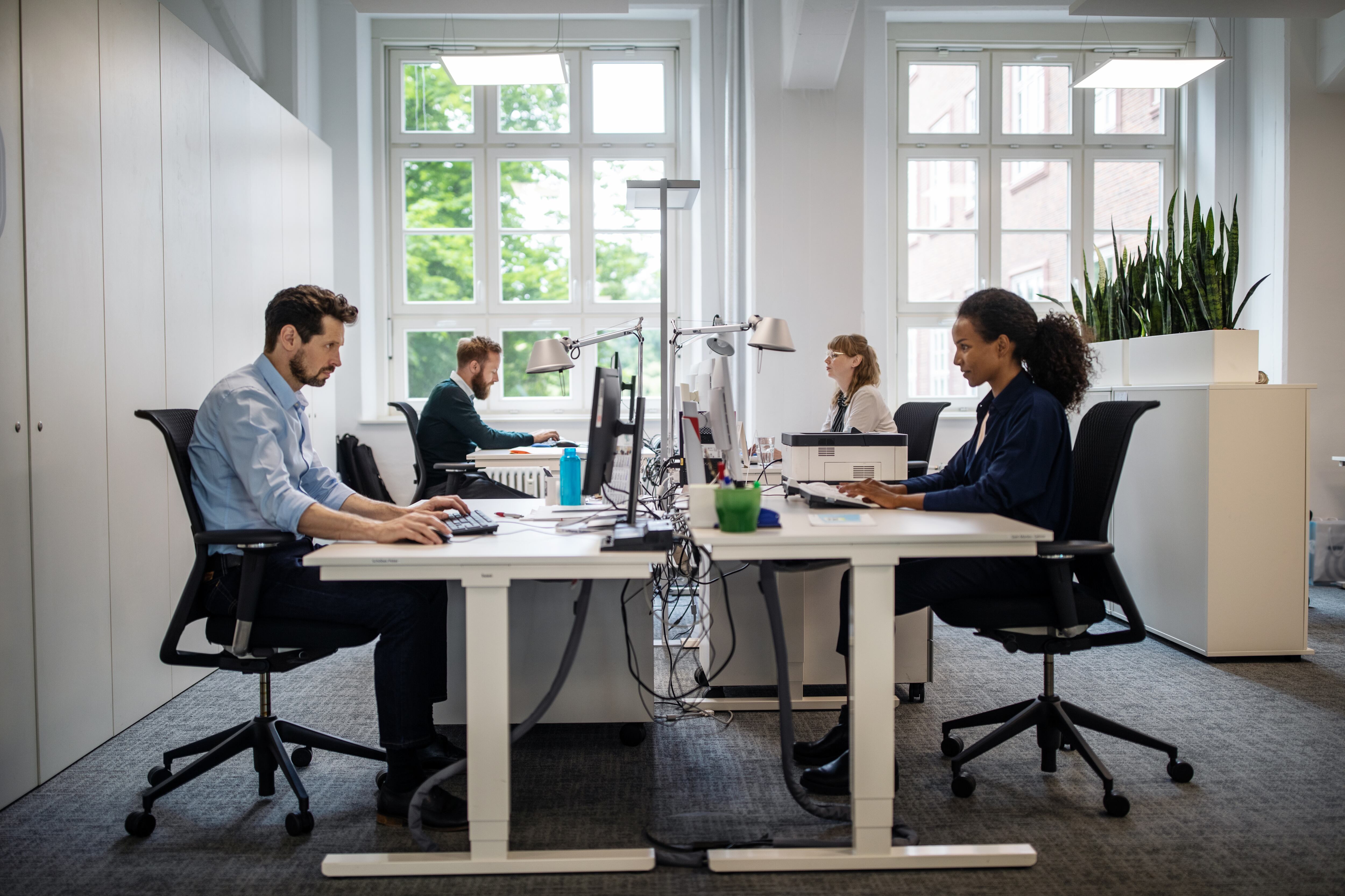 Grupo de hombres y mujeres trabajando en una empresa / Foto: GettyImages
