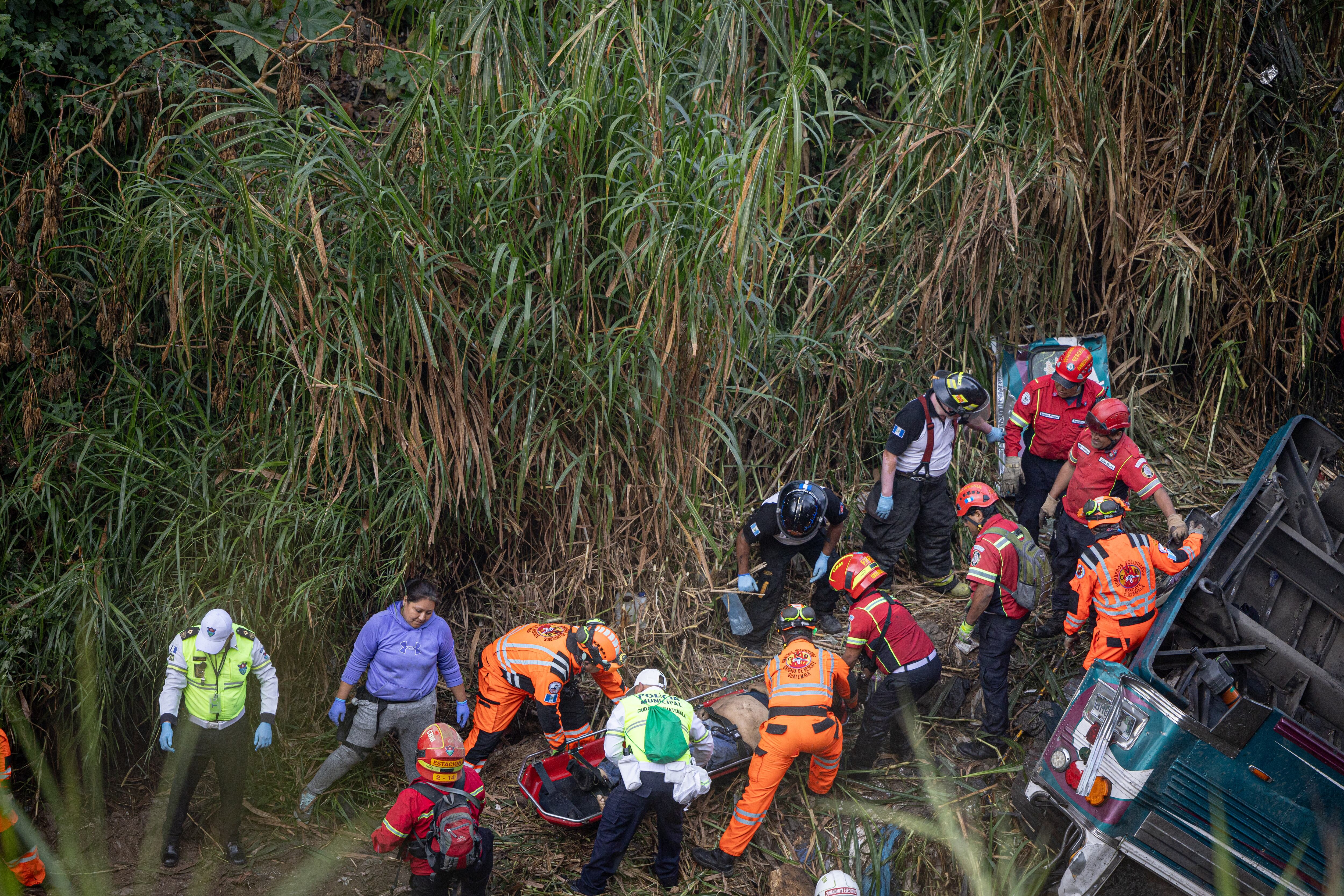 Integrantes de organismos de socorro trabajan en la zona donde ocurrió el accidente de un autobús, que cayó al norte de la Ciudad de Guatemala. FOTO: EFE/David Toro