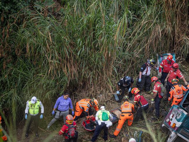Integrantes de organismos de socorro trabajan en la zona donde ocurrió el accidente de un autobús, que cayó al norte de la Ciudad de Guatemala. FOTO: EFE/David Toro