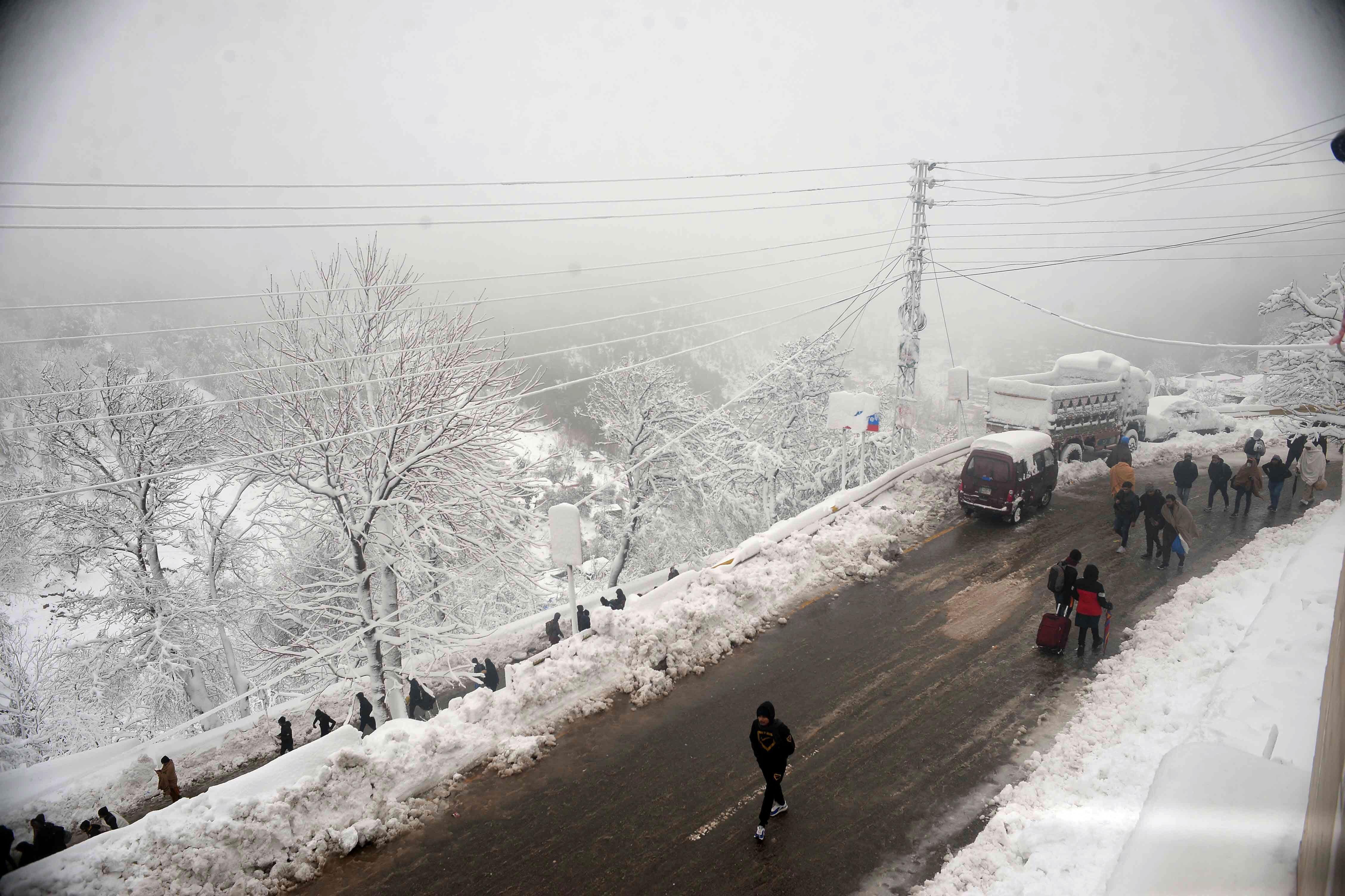 MURREE, PAKISTAN - JAN 10: Pakistani people make their way back to homes as life returns to normal following a blizzard that killed 22 people in the hilly resort town of Murree, some 50 kilometers north of Islamabad, Pakistan, on January 10, 2022. At least 22 people have died, including a family of eight and another family of five over the weekend, officials said, adding the dead include men, women and children. (Photo by Muhammad Reza/Anadolu Agency via Getty Images)