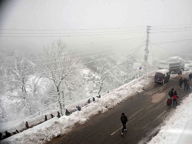 MURREE, PAKISTAN - JAN 10: Pakistani people make their way back to homes as life returns to normal following a blizzard that killed 22 people in the hilly resort town of Murree, some 50 kilometers north of Islamabad, Pakistan, on January 10, 2022. At least 22 people have died, including a family of eight and another family of five over the weekend, officials said, adding the dead include men, women and children. (Photo by Muhammad Reza/Anadolu Agency via Getty Images)