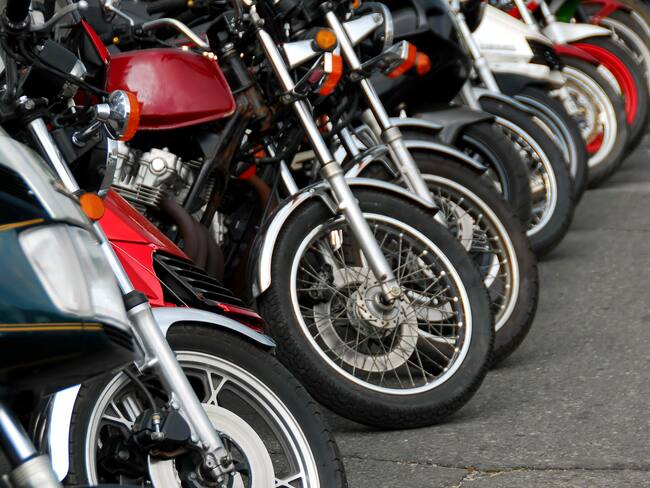 Row of motocycles parked on a street in front a motorcycle store