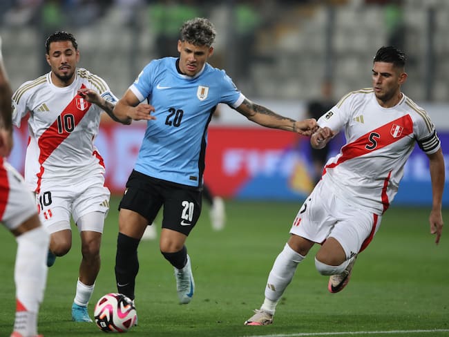 . LIMA (PERÚ), 11/10/2024.- Sergio Peña (i) y Carlos Augusto Zambrano (d) de Perú disputan un balón con Maximiliano Araújo (c) de Uruguay este viernes, en un partido de las eliminatorias sudamericanas para el Mundial de 2026 entre Perú y Uruguay en el estadio Nacional de Perú en Lima (Perú). EFE/ Paolo Aguilar