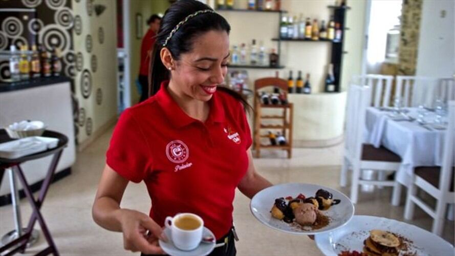 Una camarera soriente y vestida de rojo... propina a la vista. Foto: Getty Images