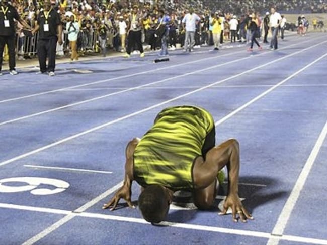 Bolt besa la pista luego de ganar una carrera de 100 metros en Kingston. Foto: Associated Press - AP