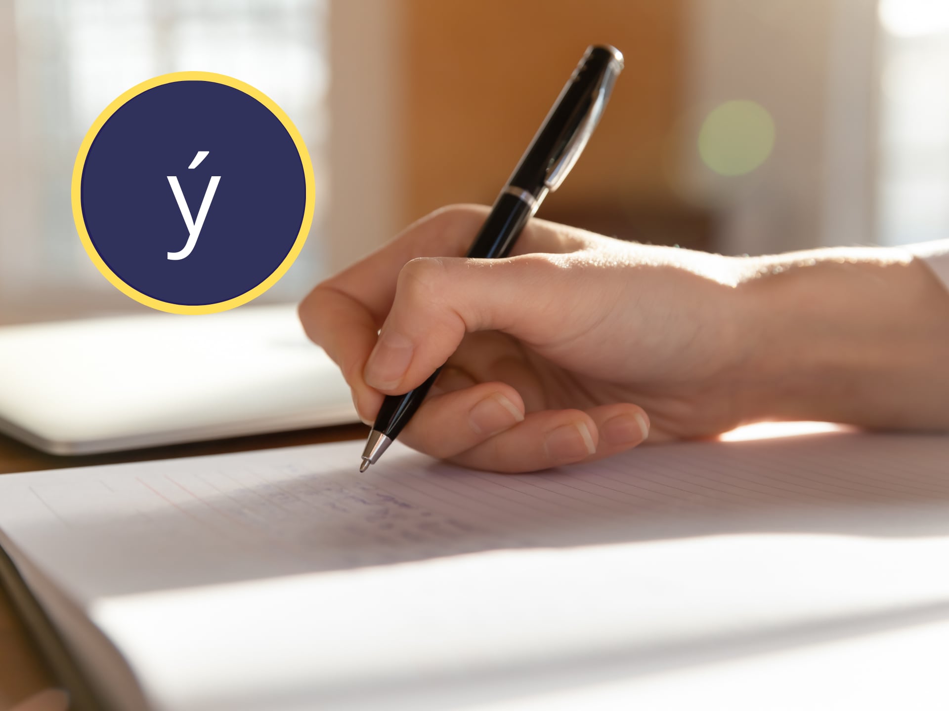 Persona escribiendo con esfero o bolígrafo en una libreta. En el círculo, la letra 'y' con tilde (GettyImages)