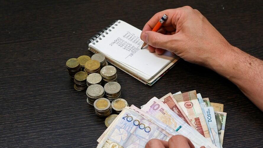 Persona haciendo cuentas con dinero colombiano. Foto: Getty Images: Ricardo Vallejo / EyeEm