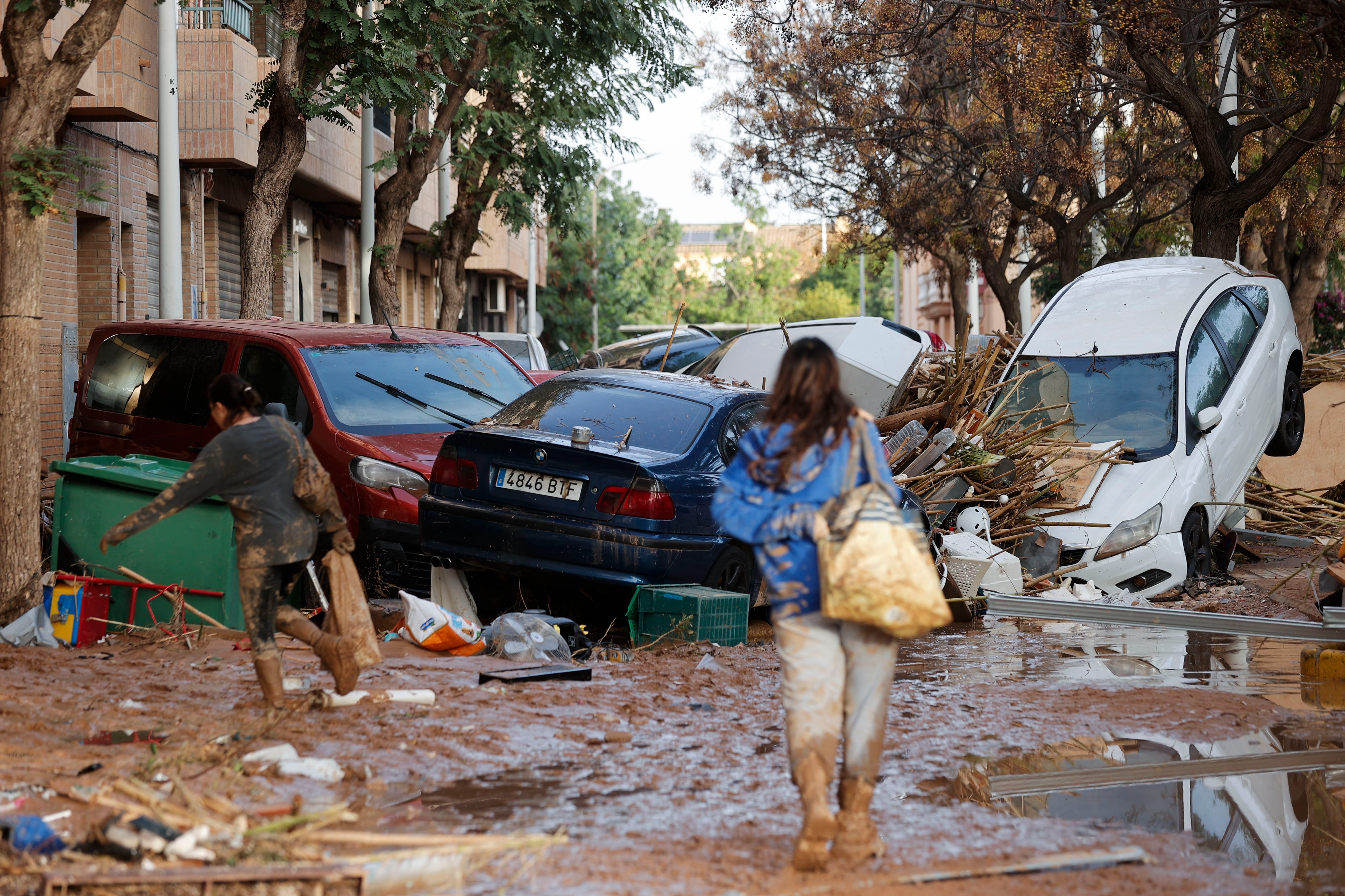 CATARROJA (VALENCIA), 31/10/2024.- Varias personas caminan entre el lodo acumulado en las calles tras las intensas lluvias caídas por la dana. (EFE/Manuel Bruque)