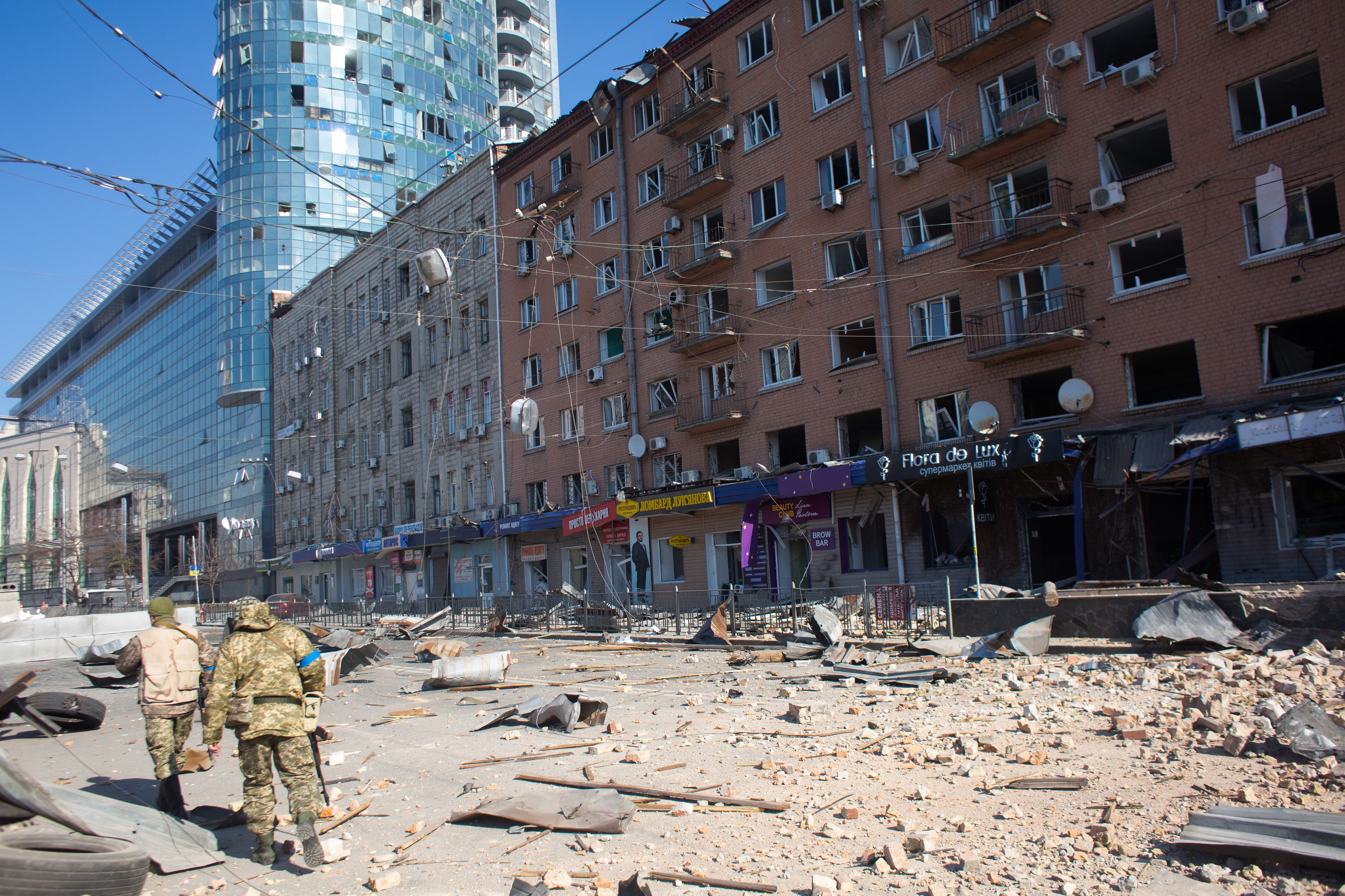 KYIV, UKRAINE - MARCH 15: Ukrainian servicemen are seen by the building which got shelled near Lukyanivska metro station on March 15, 2022 in Kyiv, Ukraine. Russian forces continue to attempt to encircle the Ukrainian capital, although they have faced stiff resistance and logistical challenges since launching a large-scale invasion of Ukraine last month. Russian troops are advancing from the northwest and northeast of the city. (Photo by Anastasia Vlasova/Getty Images)